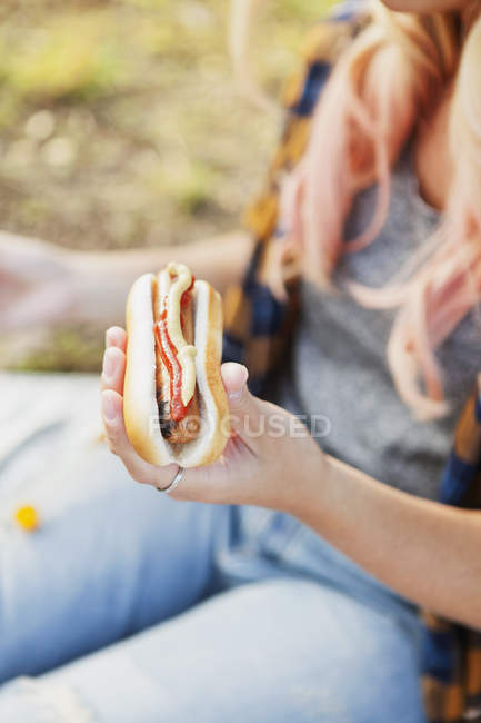 Mujer sosteniendo hot dog - foto de stock