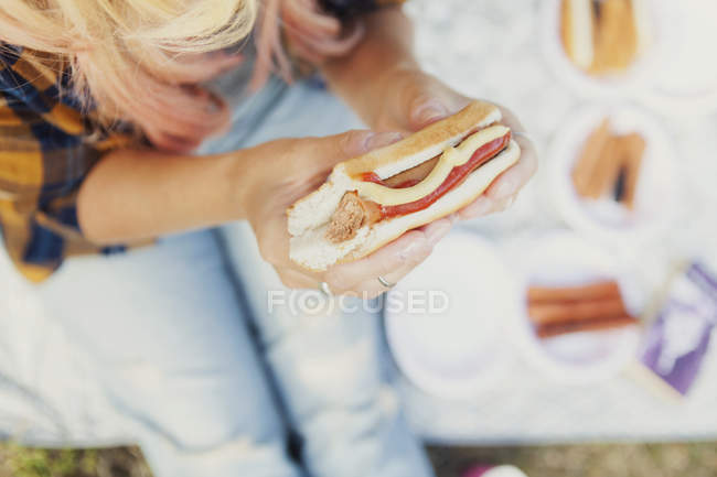 Frau hält Hotdog in der Hand — Stockfoto