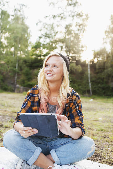Усміхнена жінка тримає цифровий планшет — стокове фото