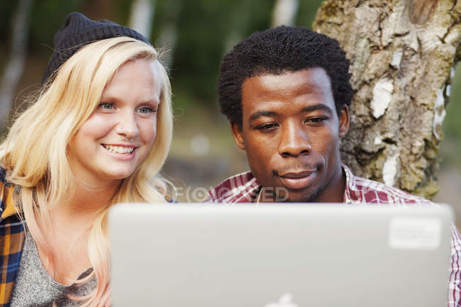 Multi-ethnic couple using laptop — Stock Photo