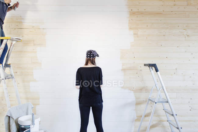 Mujer pintura pared de madera - foto de stock