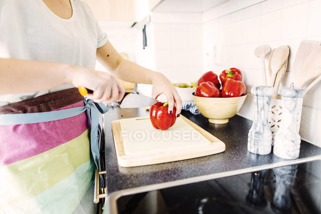 Mulher cortando pimentas vermelhas — Fotografia de Stock
