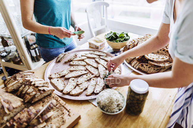 Amici che preparano panini faccia aperta — Foto stock