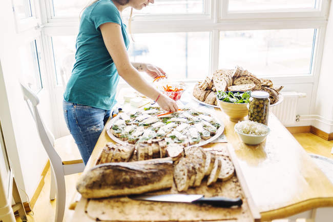 Mulher preparando sanduíches de rosto aberto — Fotografia de Stock