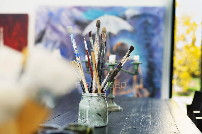 Paintbrushes in container on table — Stock Photo