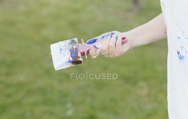 Senior woman holding paintbrush — Stock Photo