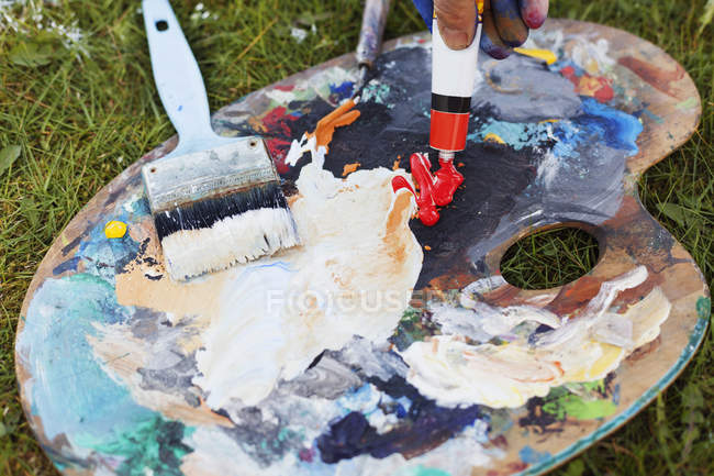 Hand spilling red paint — Stock Photo