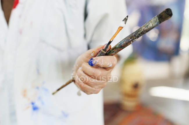 Artiste féminine tenant des pinceaux — Photo de stock