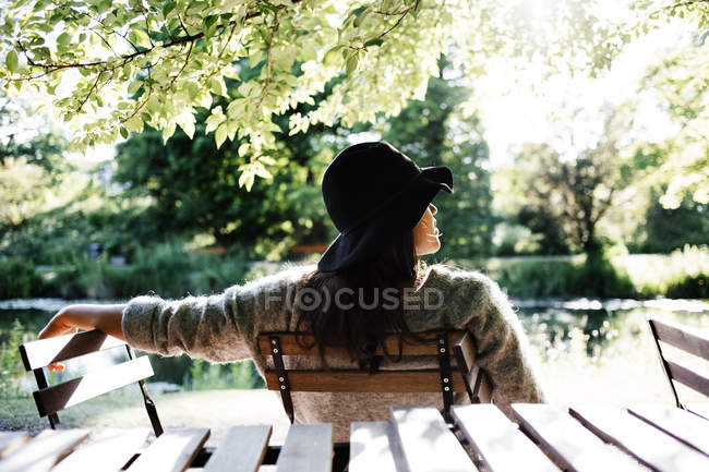 Mulher sentada na cadeira no parque — Fotografia de Stock