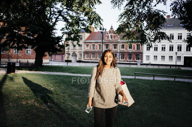 Молода жінка стоїть в парку — стокове фото