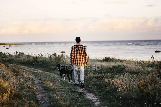 Человек с собакой, прогуливающийся по рельсам — стоковое фото