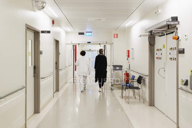Mujeres caminando en el pasillo del hospital - foto de stock