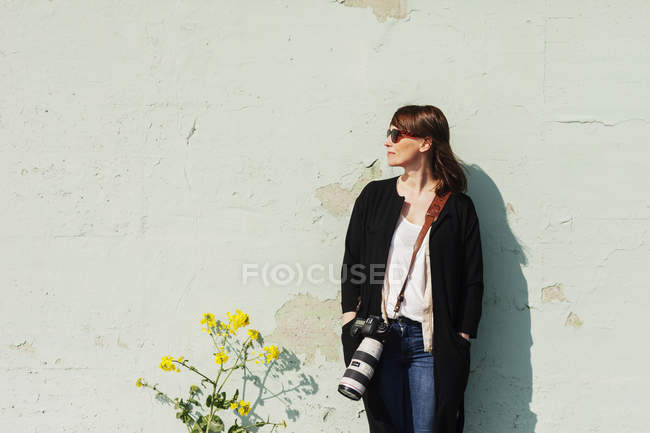 Jeune femme avec appareil photo reflex — Photo de stock