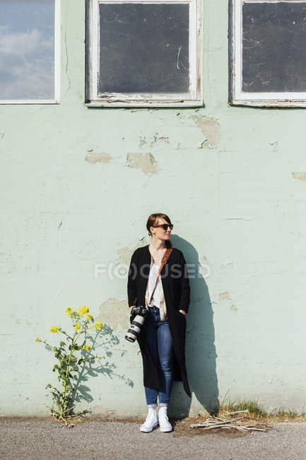 Fotógrafa feminina apoiada na parede — Fotografia de Stock