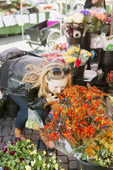 Frau riecht Blumen — Stockfoto