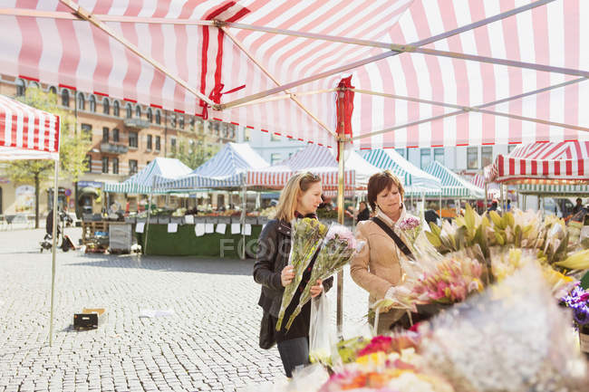 Mature women buying flowers — Stock Photo