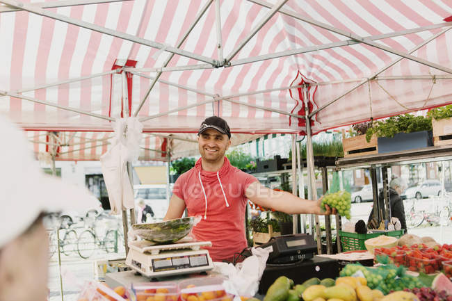 Venditore maschio che vende frutta — Foto stock