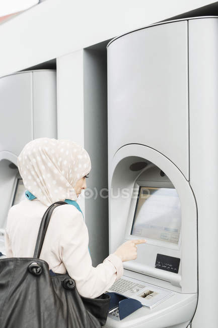 Femme utilisant la machine à billets — Photo de stock