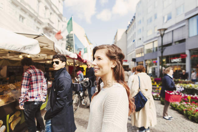Усміхнена жінка дивиться на ринок стебло — стокове фото
