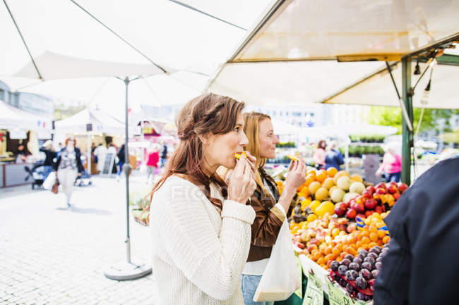 Mujeres comiendo fruta - foto de stock