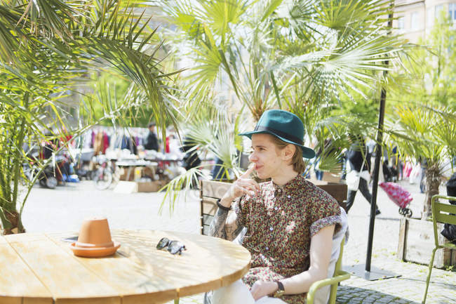 Homem usando chapéu relaxante no café — Fotografia de Stock