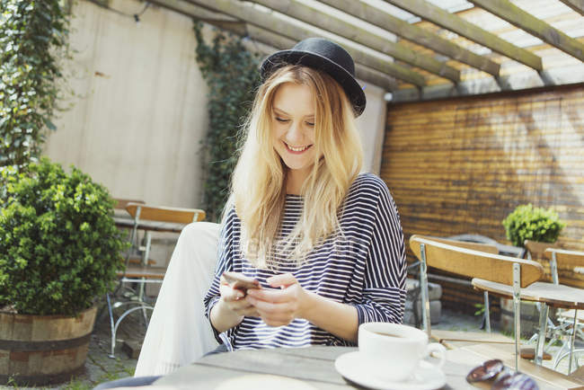 Женщина в шляпе с помощью телефона — стоковое фото