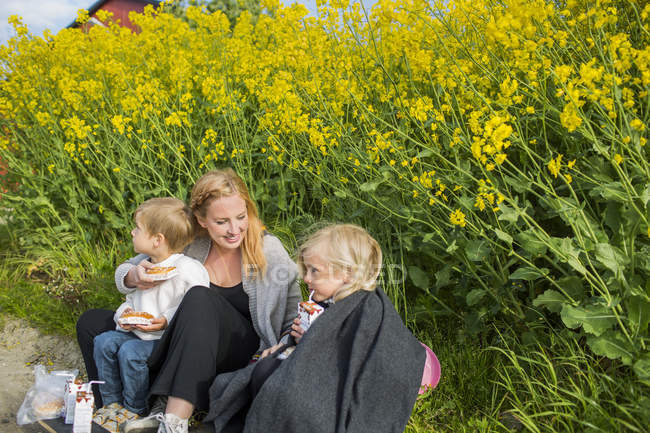 Усміхнена жінка сидить з дітьми — стокове фото