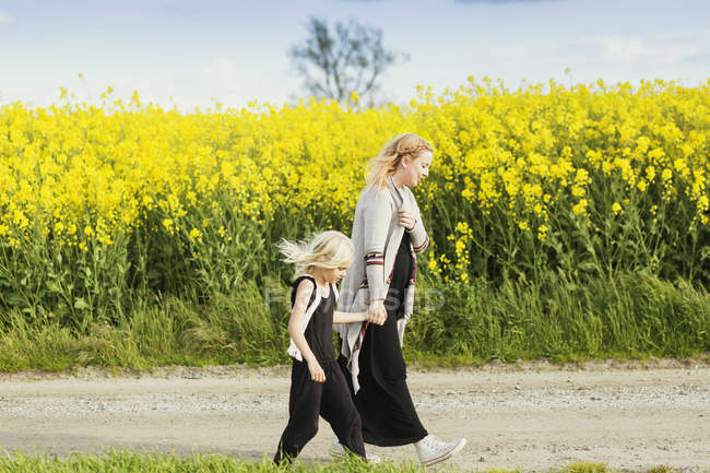 Irl walking with pregnant mother — Stock Photo