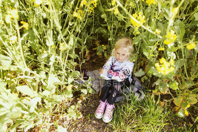 Menina sentado no meio de plantas — Fotografia de Stock