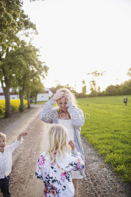 Feliz família de pé na estrada de terra — Fotografia de Stock