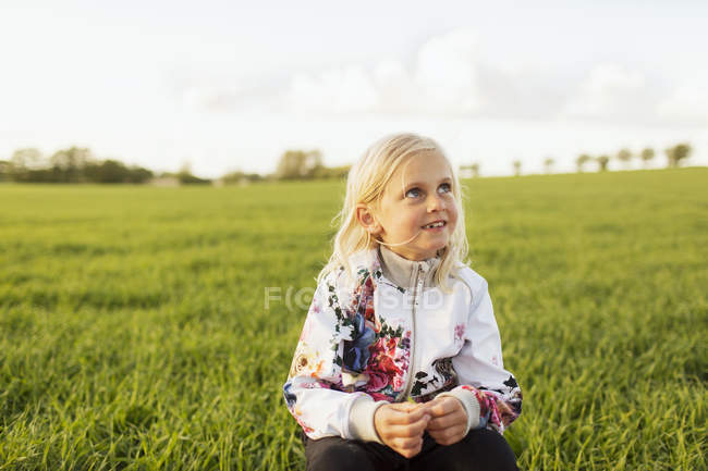 Fille assise sur herbe — Photo de stock