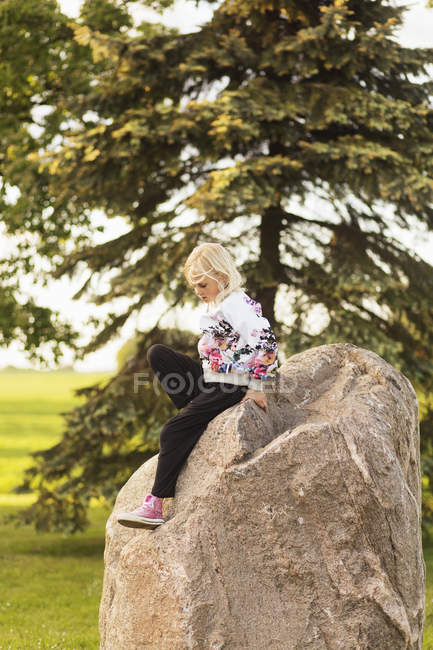 Fille assise sur le rocher — Photo de stock