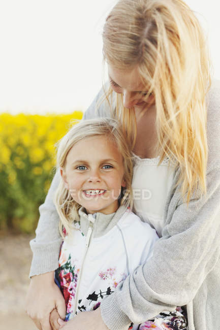 Щаслива дівчина стоїть з люблячою матір'ю — стокове фото