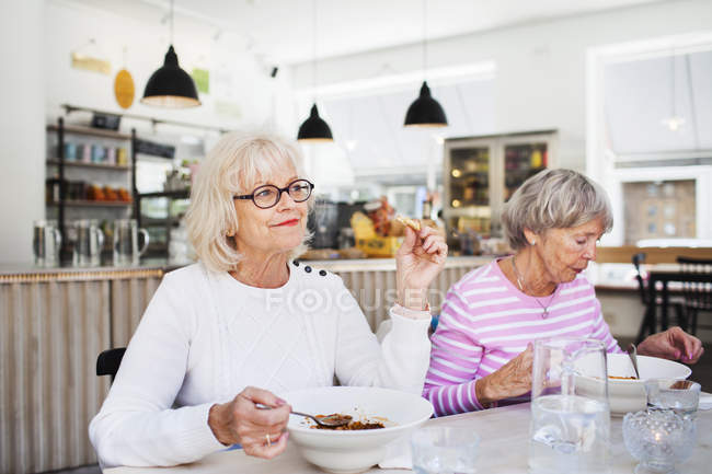 Femmes âgées mangeant des aliments — Photo de stock