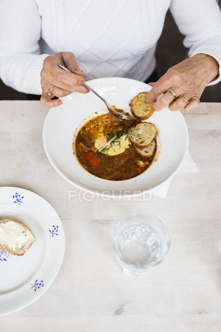 Senior woman eating food — Stock Photo