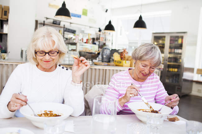 Mujeres mayores comiendo alimentos - foto de stock