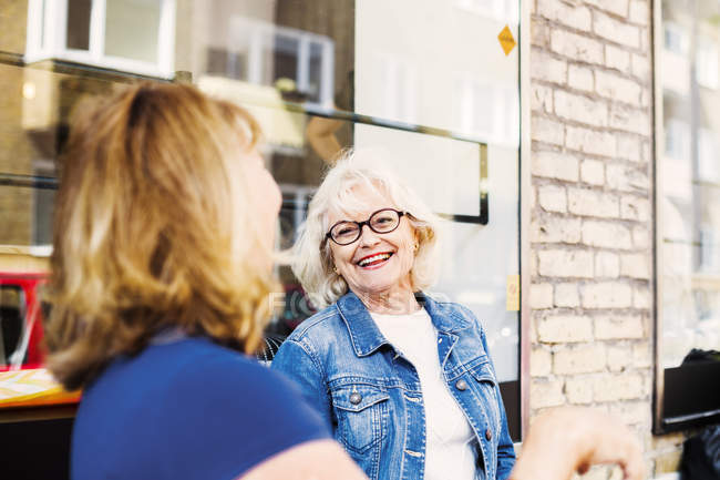 Старшие женщины смеются в кафе — стоковое фото