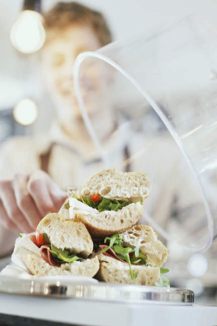 Travailleur arrangeant sandwich — Photo de stock