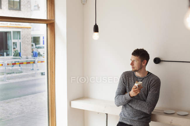 Удумливий чоловік тримає чашку кави — стокове фото
