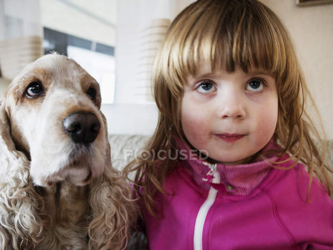 Girl with dog at home — Stock Photo