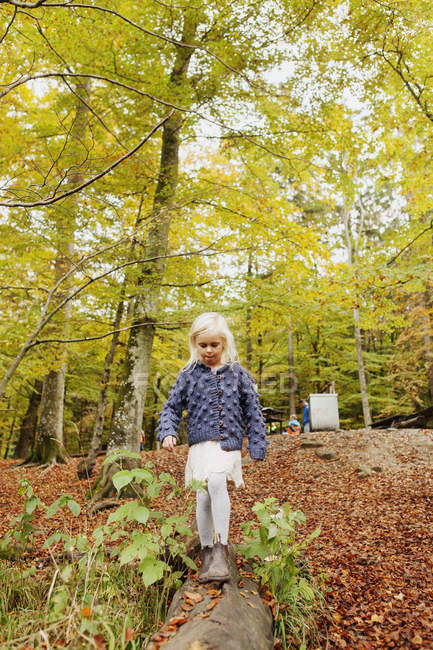 Mädchen läuft auf Baumstamm im Park — Stockfoto