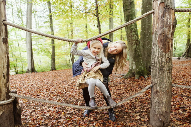 Glückliche Mutter hilft Mädchen beim Balancieren — Stockfoto