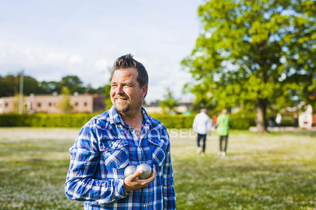 Uomo che tiene palle boule al parco — Foto stock