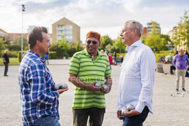 Male friends talking while playing boule — Stock Photo