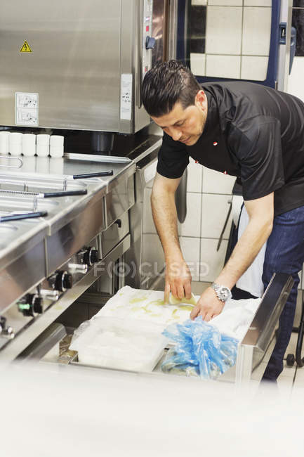 Мужчина шеф-повар, работающий на кухне в ресторане — стоковое фото