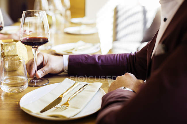 Чоловік тримає червоний келих вина — стокове фото
