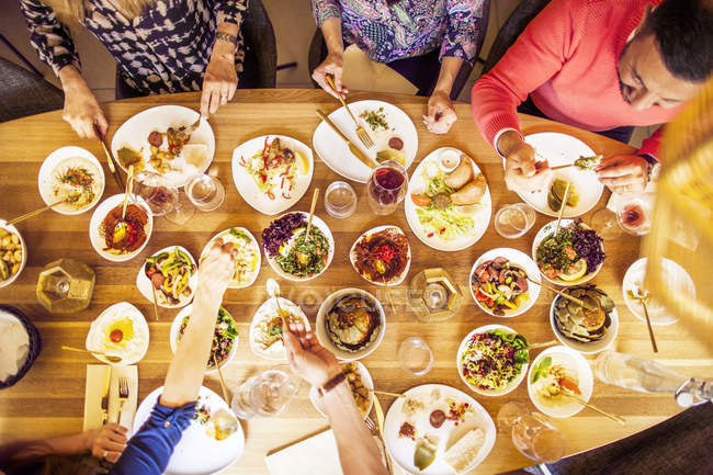 Amigos cenando en la mesa - foto de stock