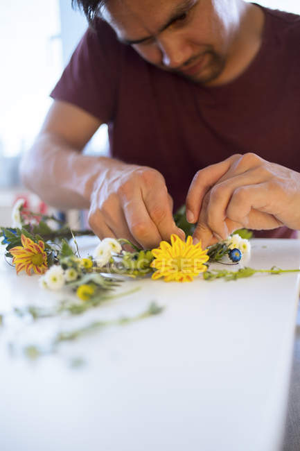 Чоловік робить квітковий вінок — стокове фото