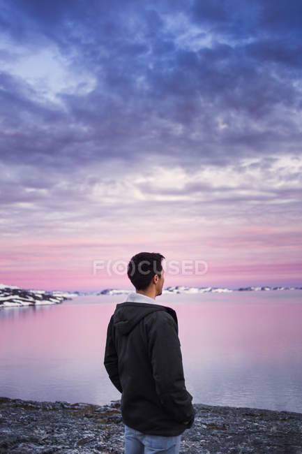 Homem olhando para a paisagem coberta de neve — Fotografia de Stock