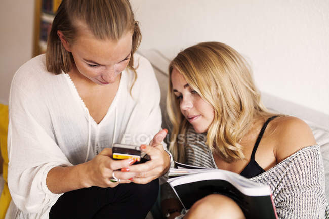 Young women using phone — Stock Photo